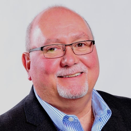 Middle-aged man with glasses, receding hairline, and goatee smiling at camera
