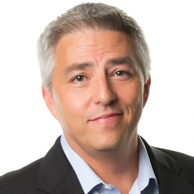 Middle-aged man with gray hair wearing dark blazer and light blue shirt