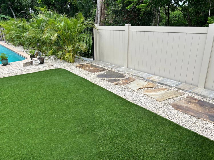 tampa bay artificial turf installation with paver walkway and white rock landscaping