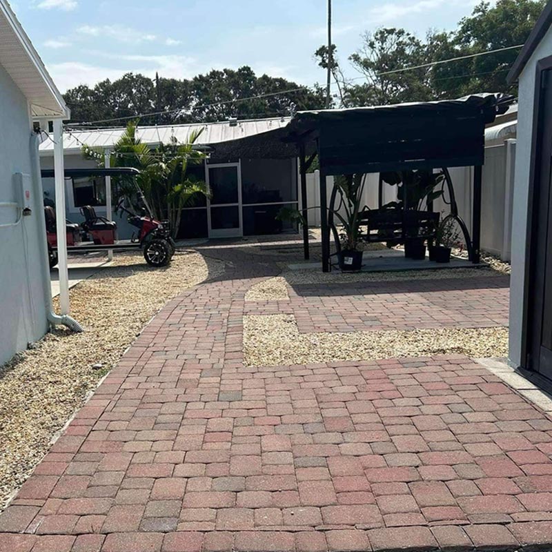 backyard before photo with paver patio and gravel layout prior to landscape redesign in Tampa Bay