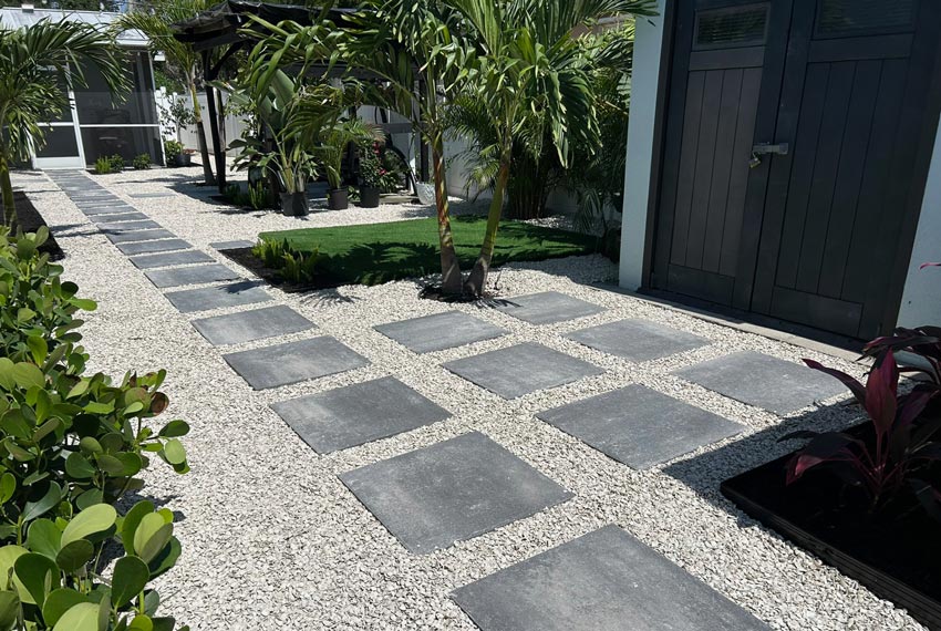 modern paver walkway with gravel and tropical landscaping for residential backyard design in Tampa Bay