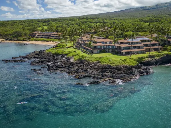 Aerial of Makena Surf on the lava point above clear water in Mākena