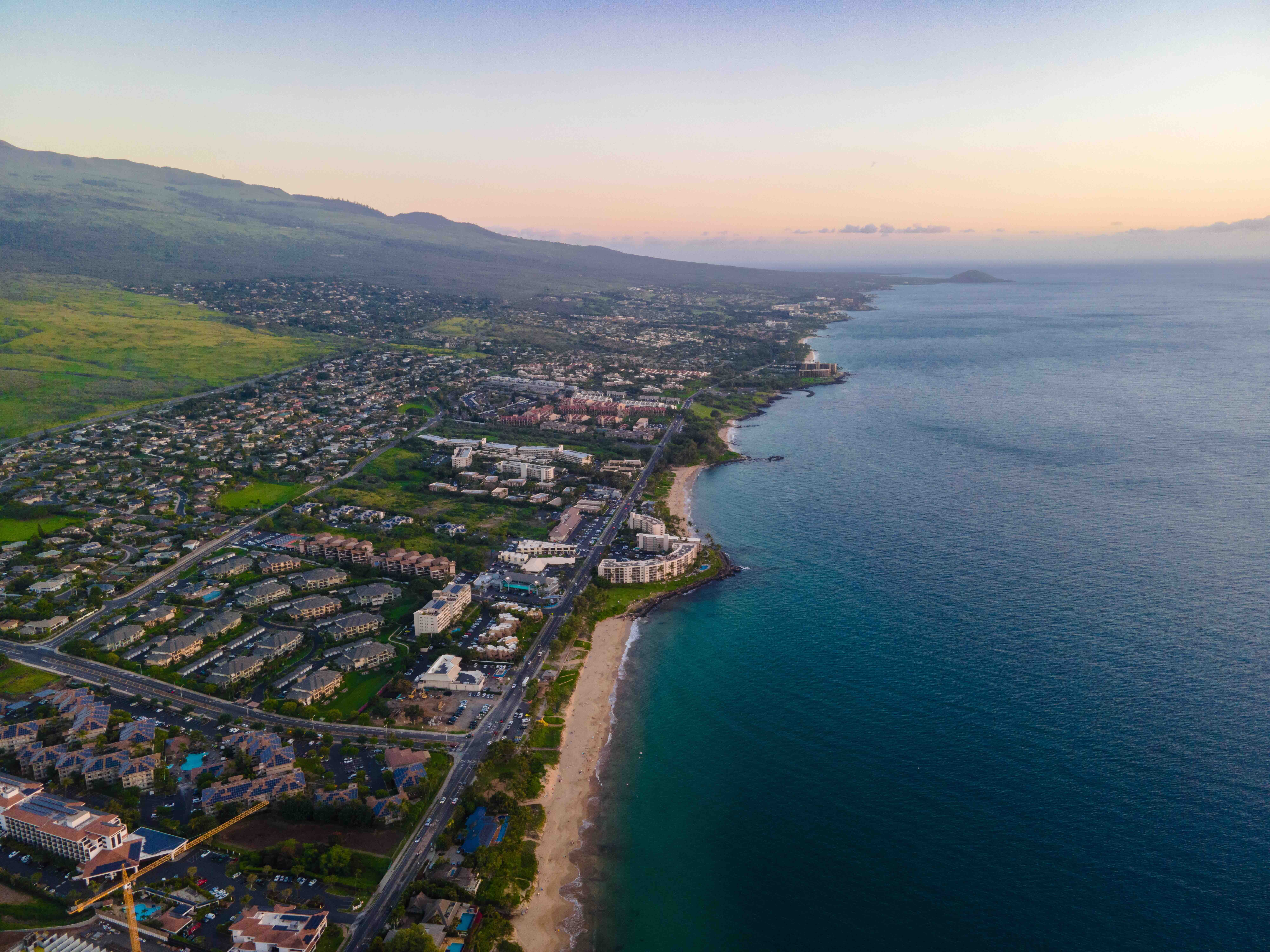 Aerial view of Kihei condos and beaches curving along the South Maui shoreline at dusk