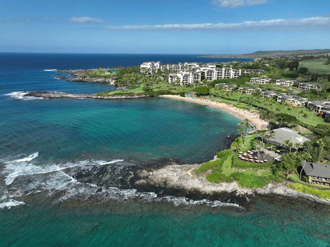 Aerial view of protected Kapalua Bay with calm turquoise water inside its rocky arms