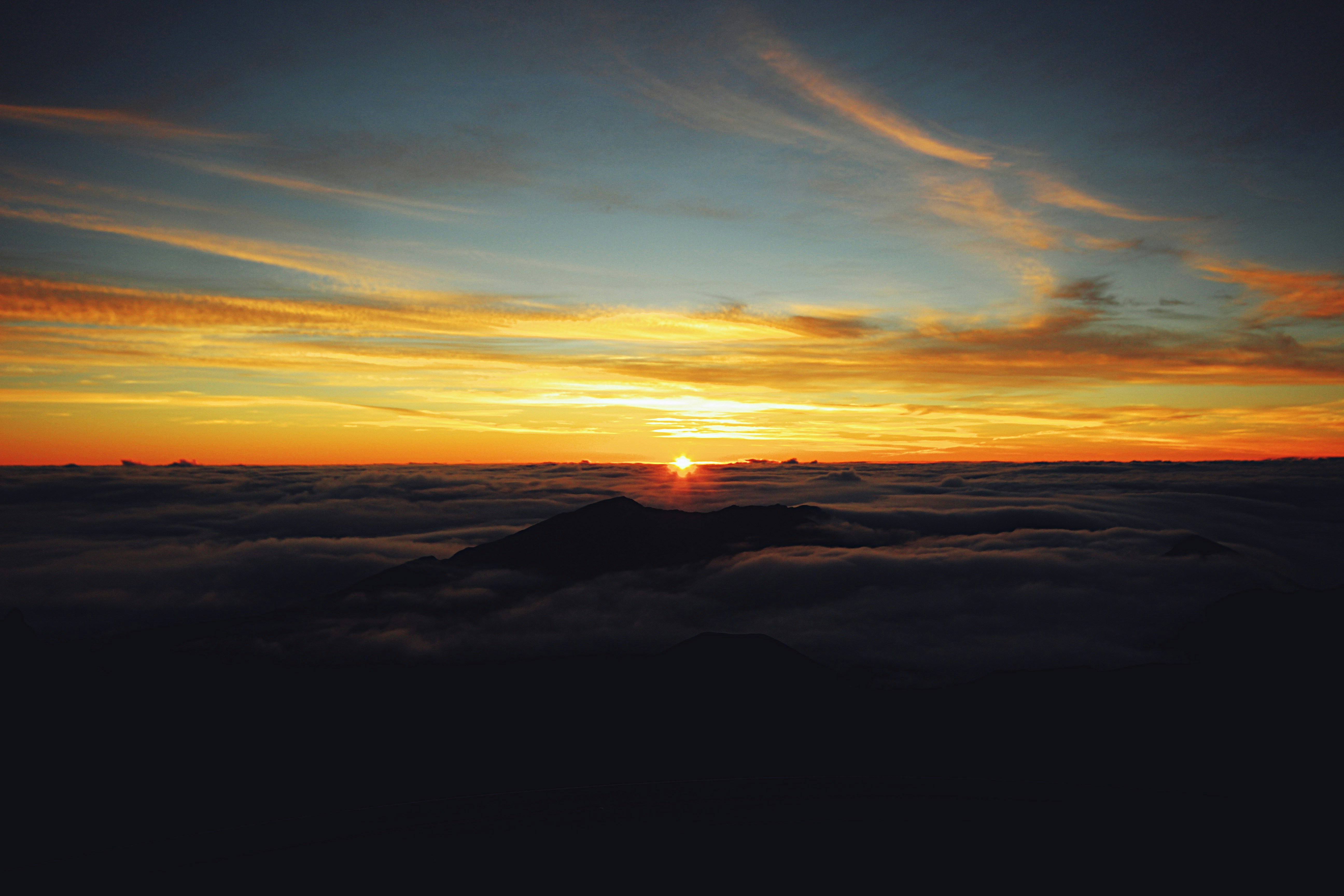 Sunrise breaking over a sea of cloud seen from the summit of Haleakala