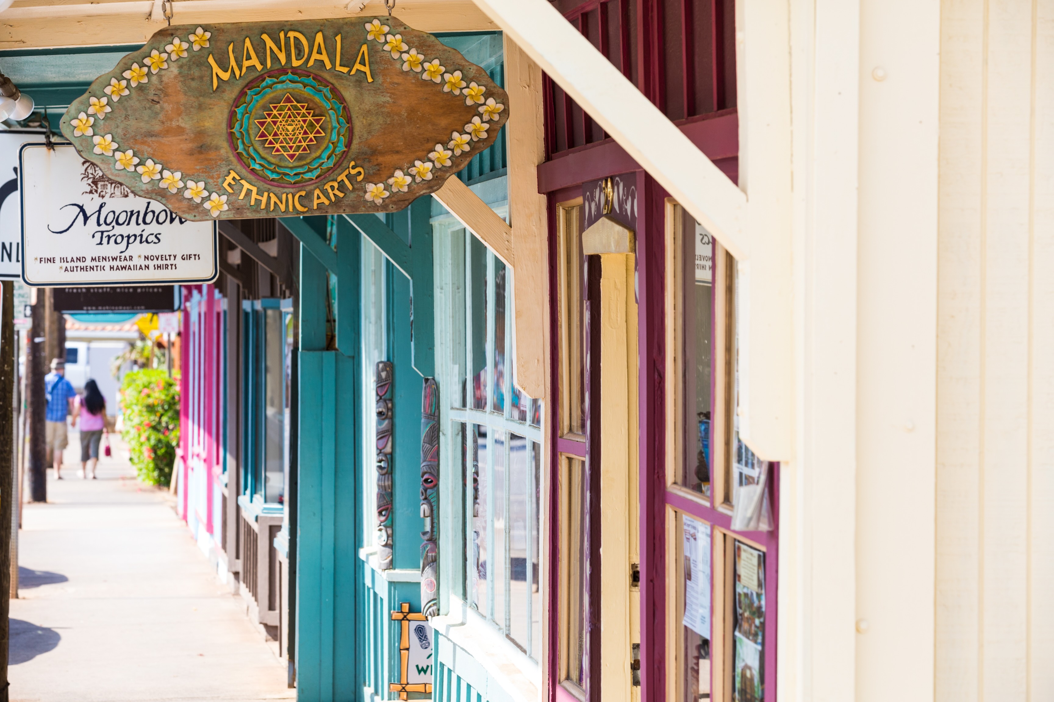 Shopfronts and awnings along the main street in Paia, with cars parked at the kerb