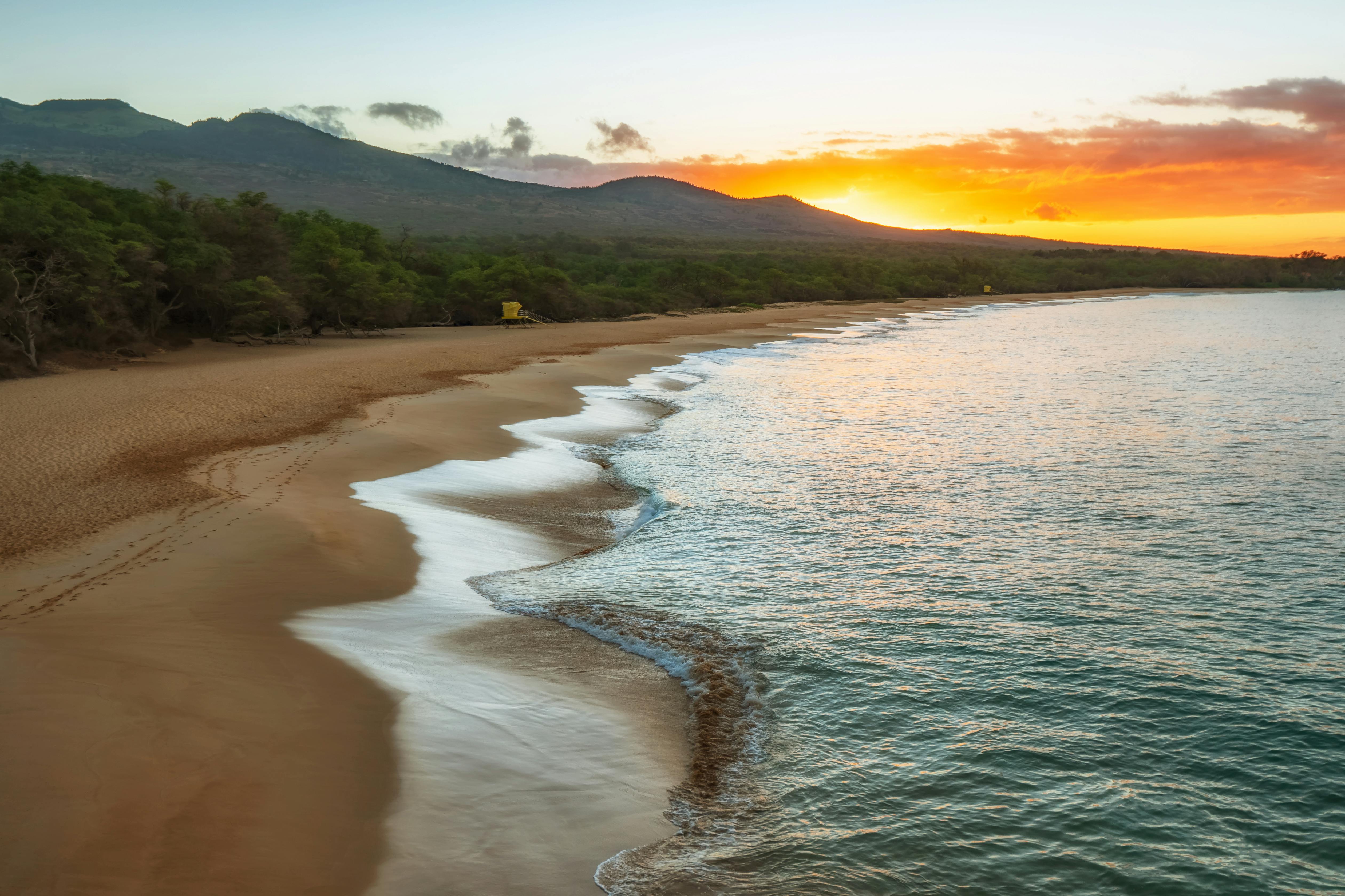 Big Beach at Makena at sunset with surf breaking along an empty stretch of sand