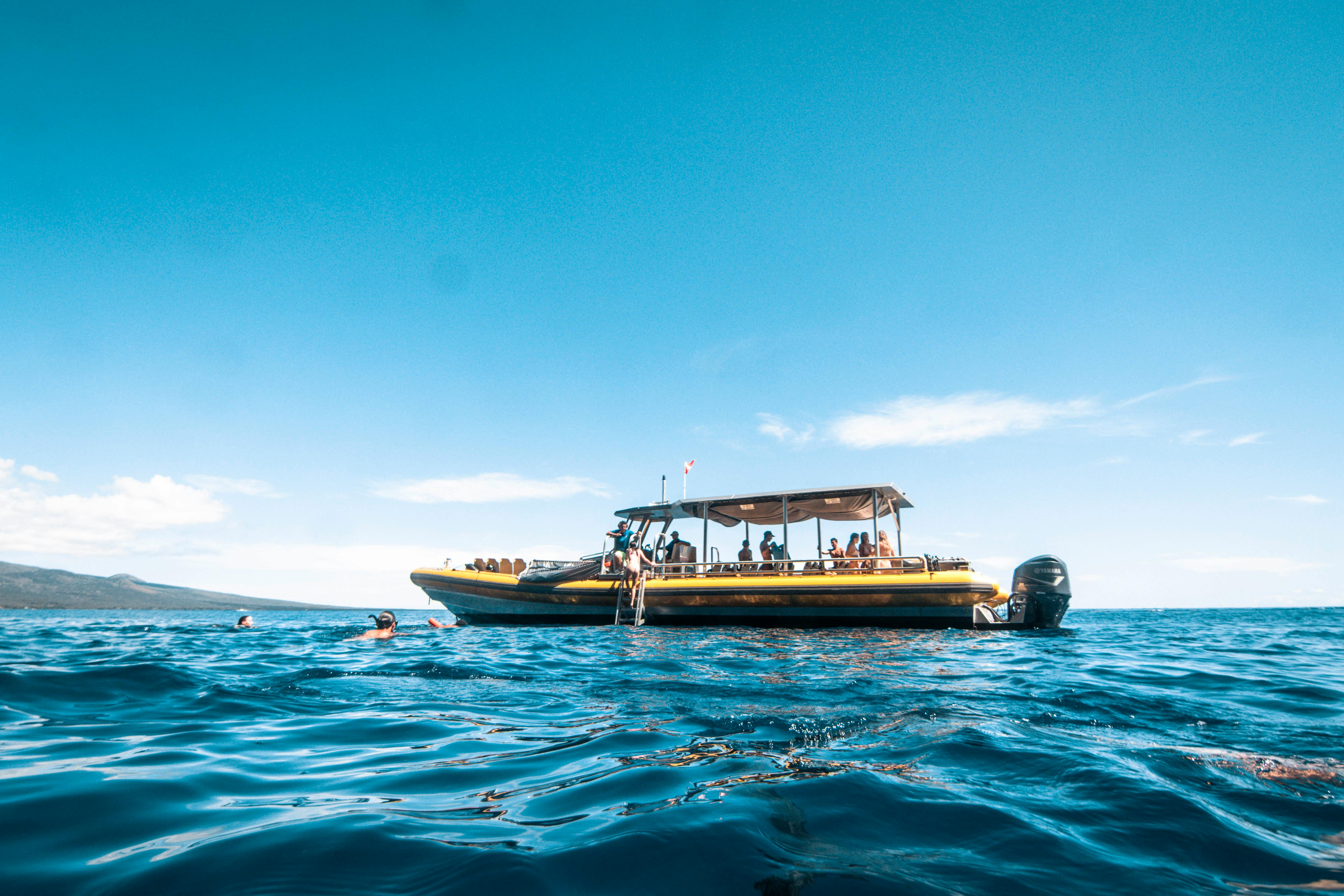 A snorkel raft anchored offshore with swimmers in the water alongside