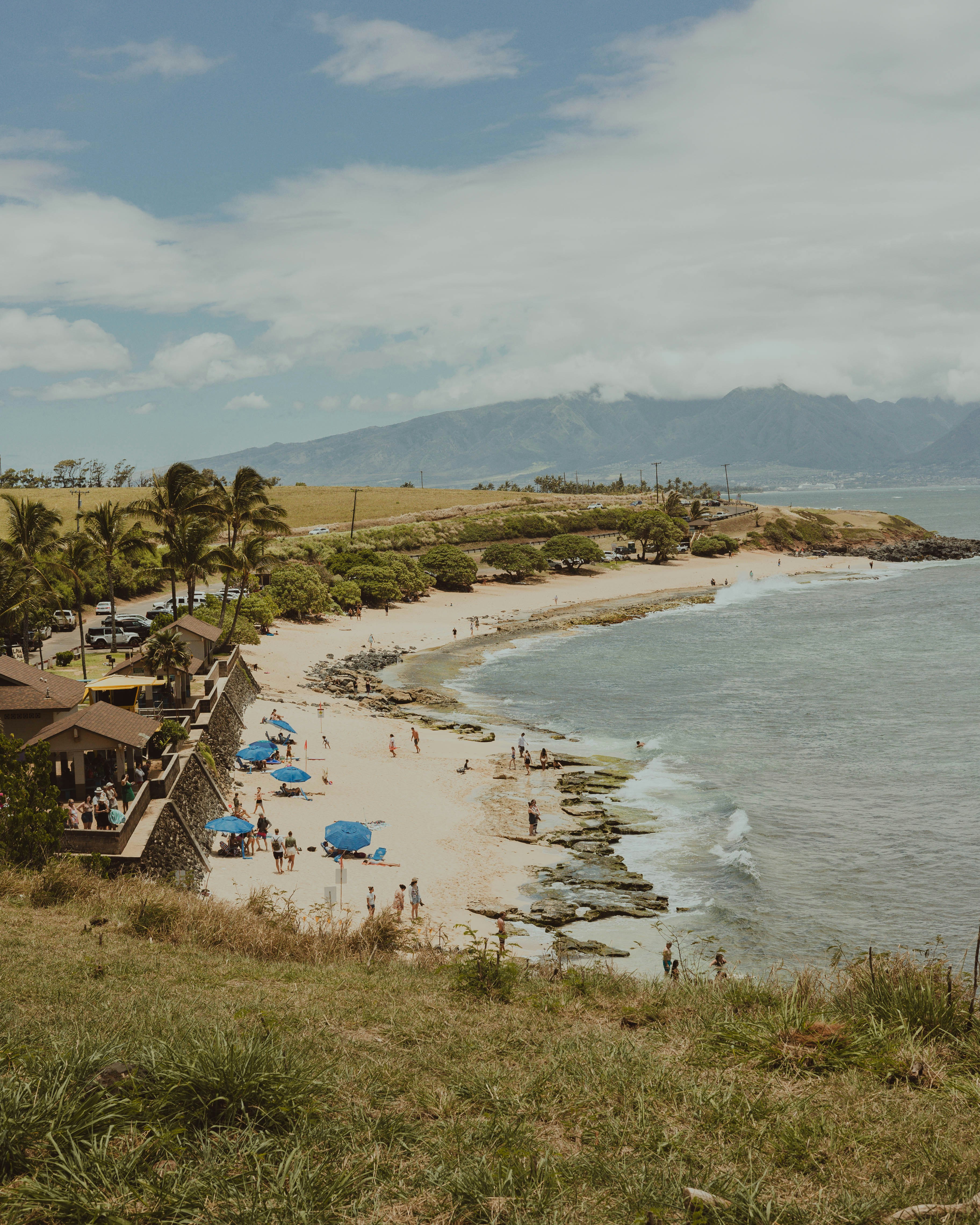 Surf breaking across the bay at Hoʻokipa with the headland lookout above
