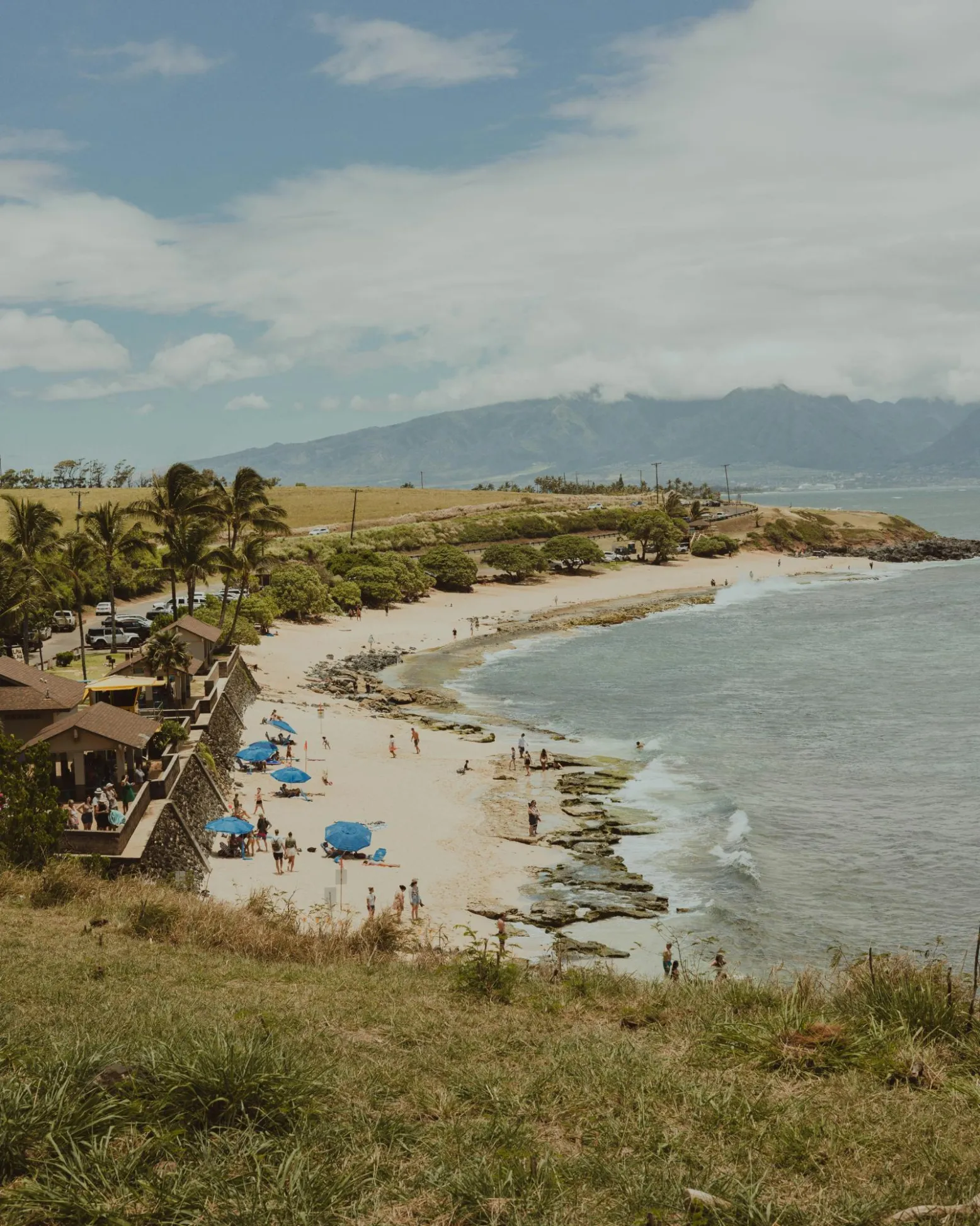 Surf breaking across the bay at Hoʻokipa with the headland lookout above