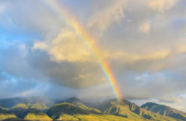 A rainbow over the West Maui Mountains with rain visible across the ridge