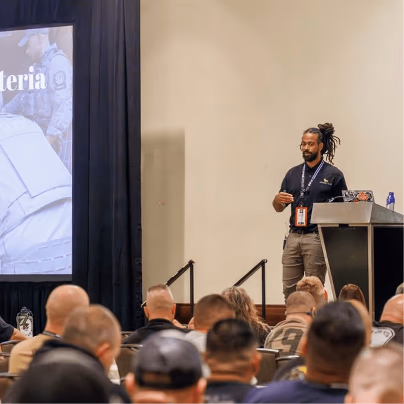 K-9 training instructor presenting selection criteria methods to a packed audience of handlers at a professional conference seminar
