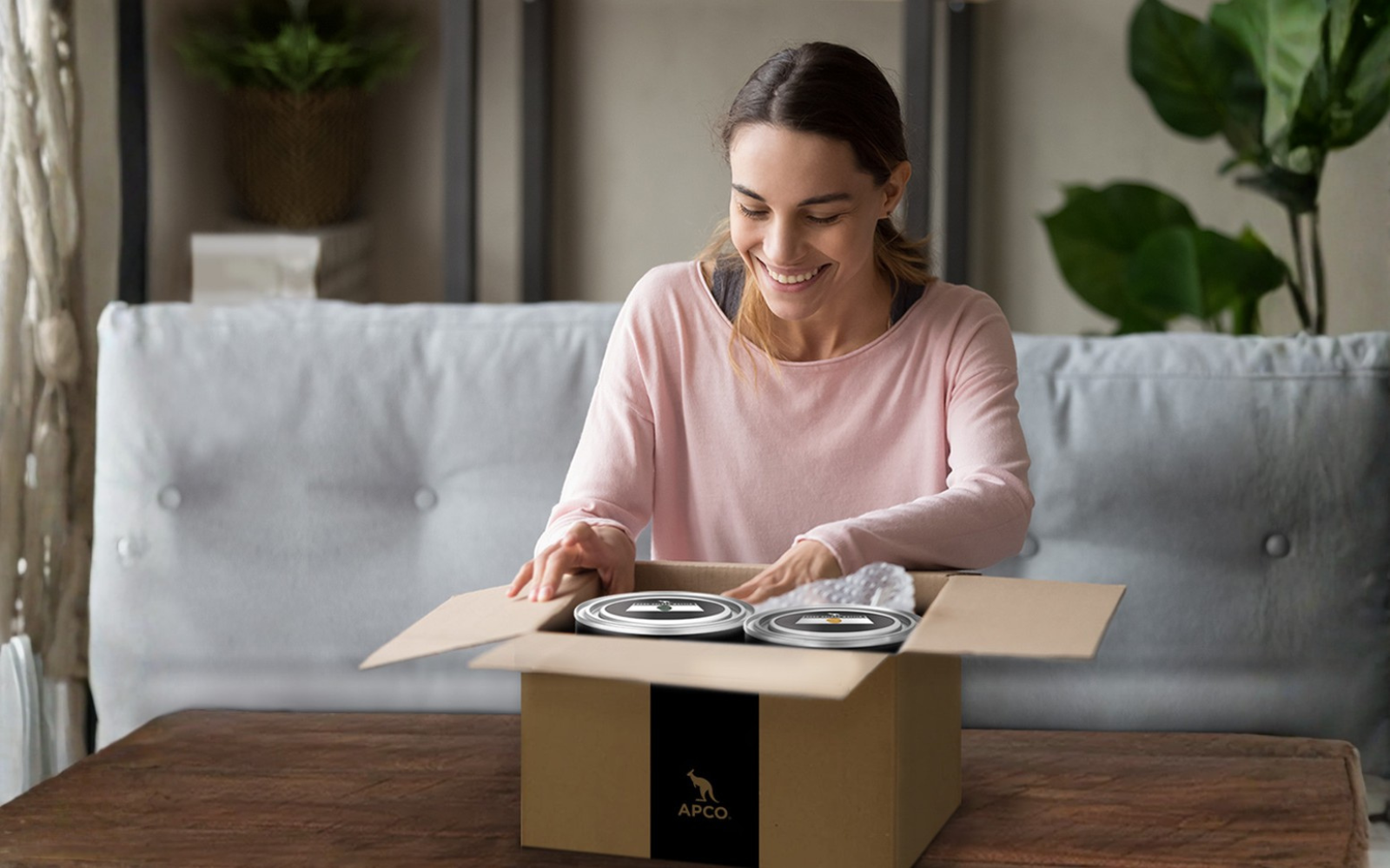 Customer opening a home delivery box of APCO paint tins