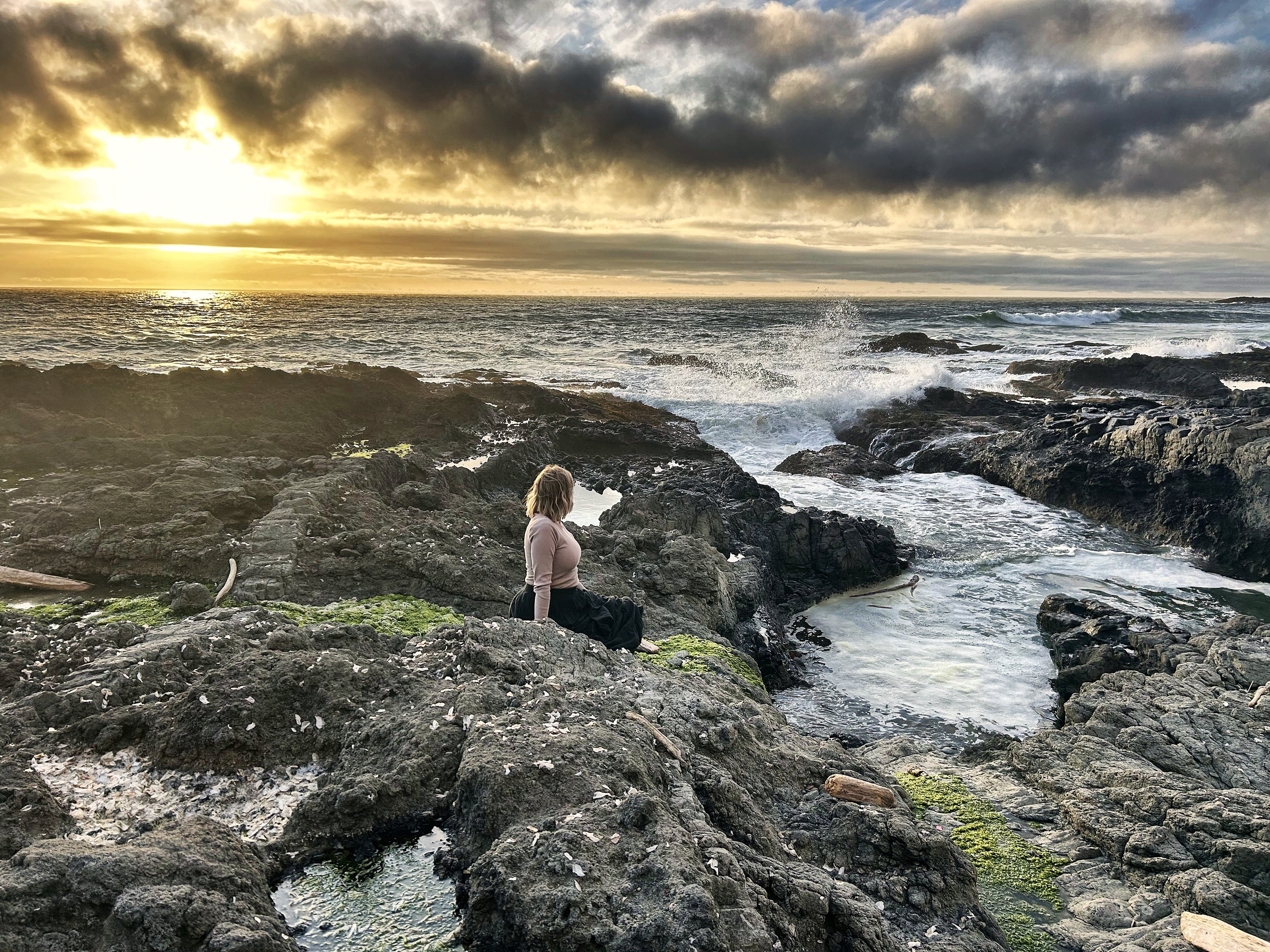 Kid watching the churning wave channel at Cape Perpetua at golden hour