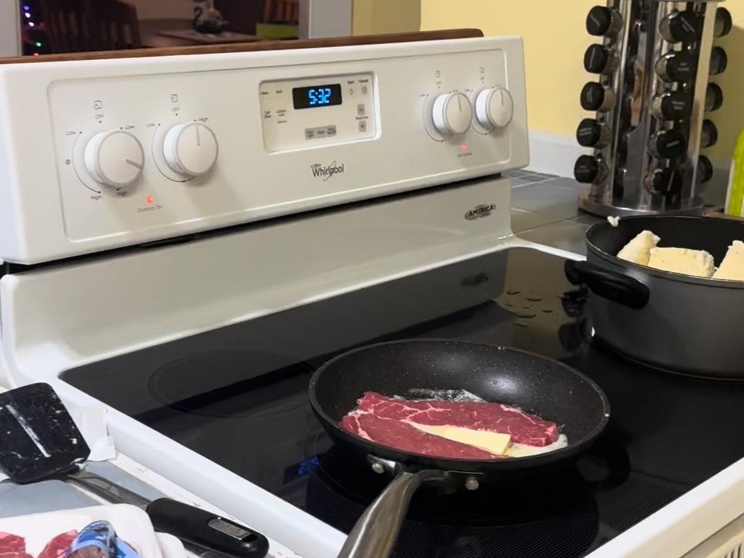 A ribeye and butter in a pan on the Swan House stove