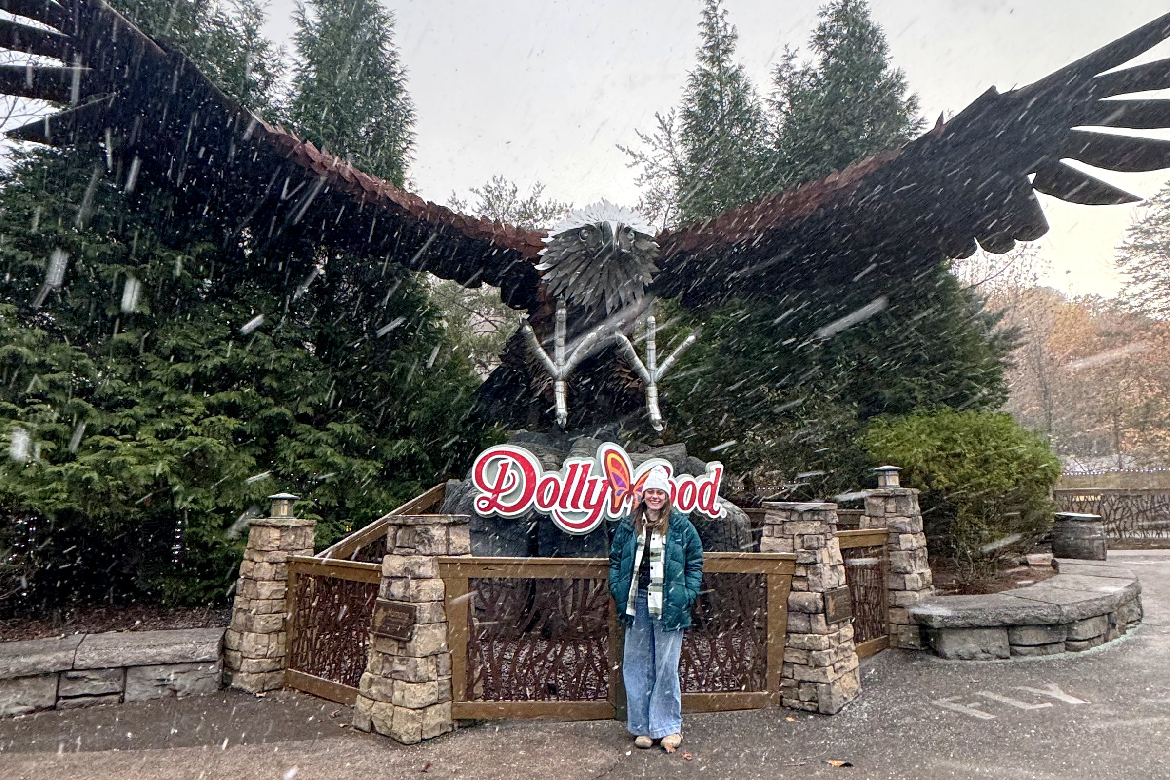 One of the girls under the Dollywood eagle sign while it snows