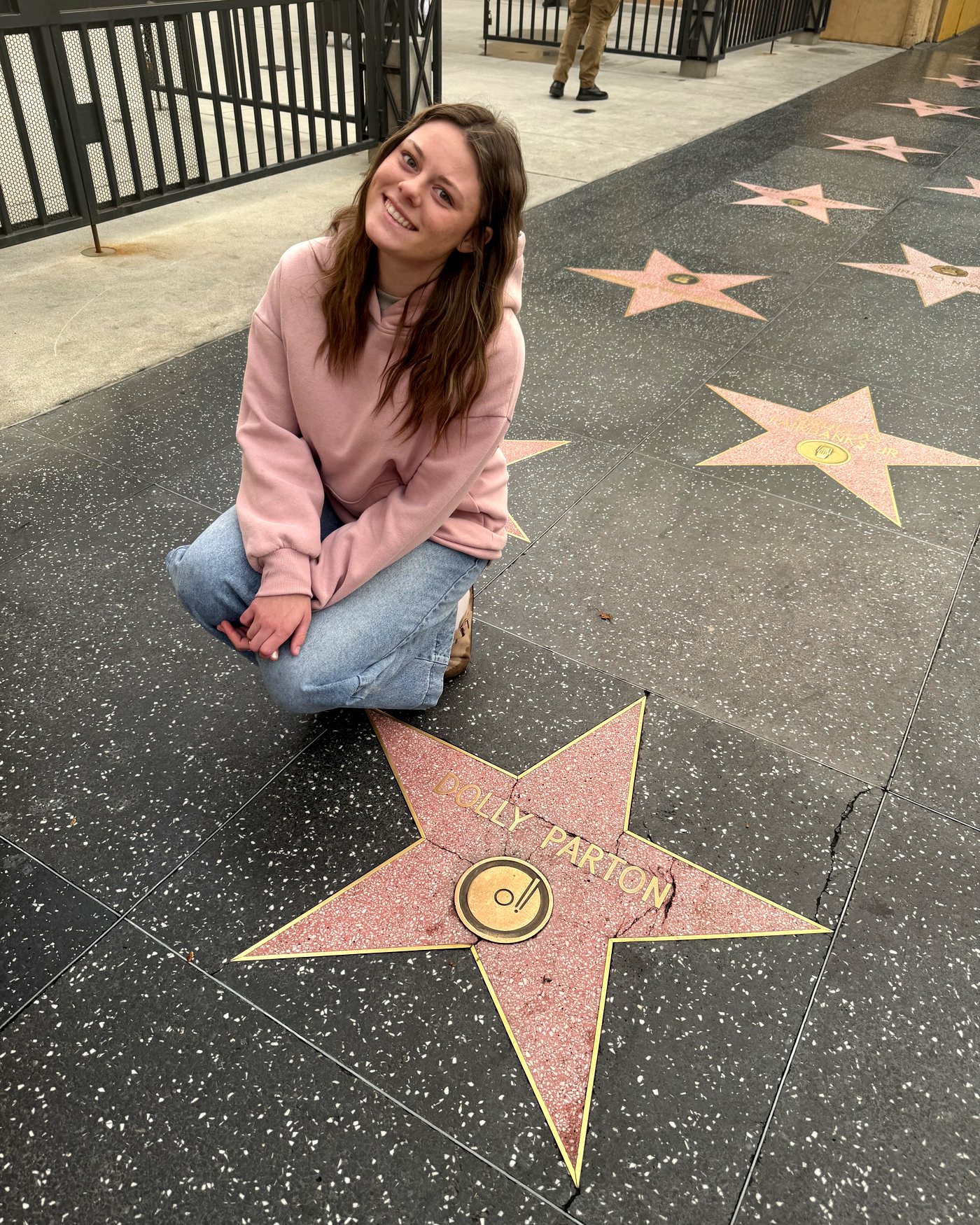 One of the girls kneeling next to Dolly Parton's star on the Hollywood Walk of Fame