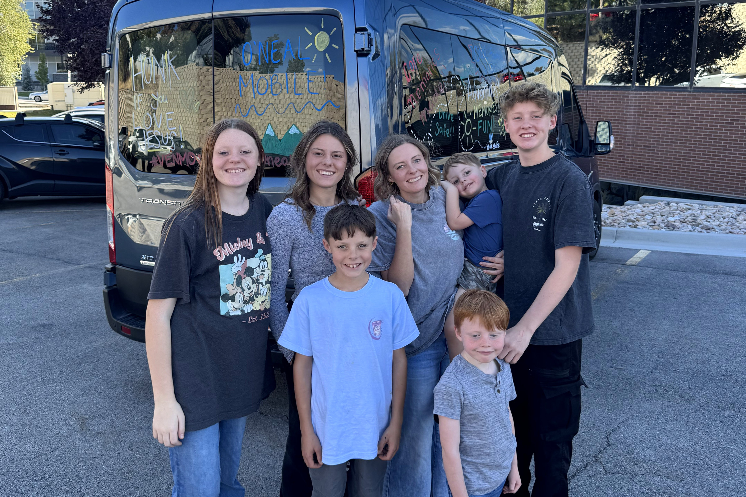 Amy and all six kids in front of the O'Neal mobile on the afternoon we left, the back windows painted