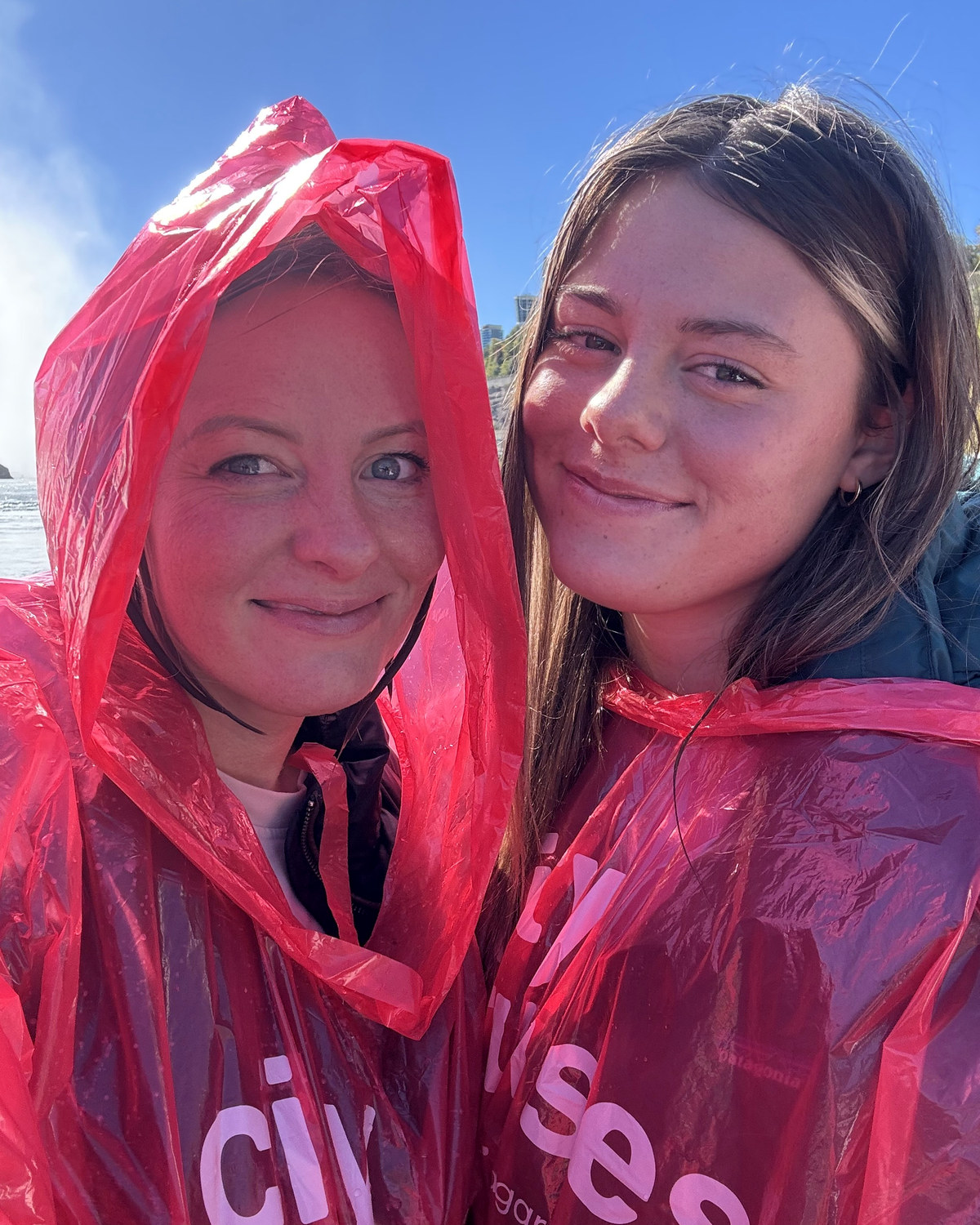 Amy and one of the girls in red ponchos on the Niagara boat, soaked and smiling