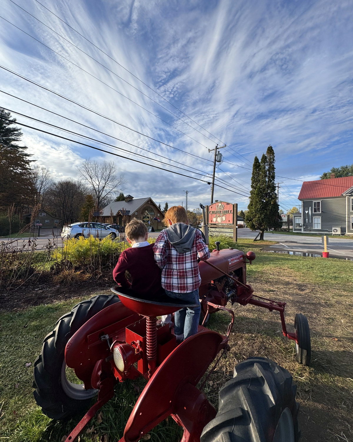 Two of the boys on the old red tractor out front of Cold Hollow Cider Mill