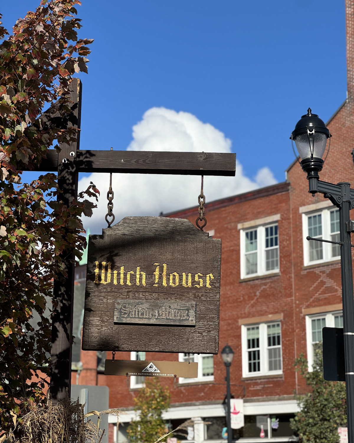 The Witch House sign in Salem against a blue October sky