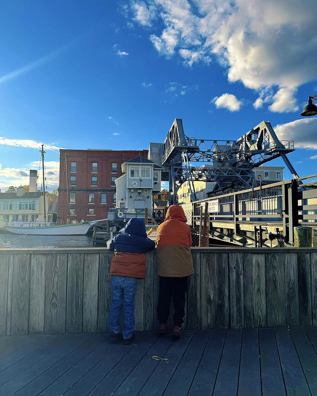 Two of the kids at the rail watching the drawbridge in Mystic, Connecticut