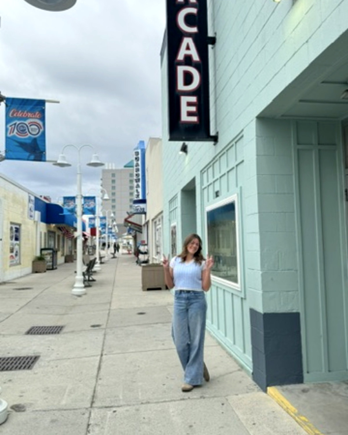 One of the girls under the arcade sign on the boardwalk