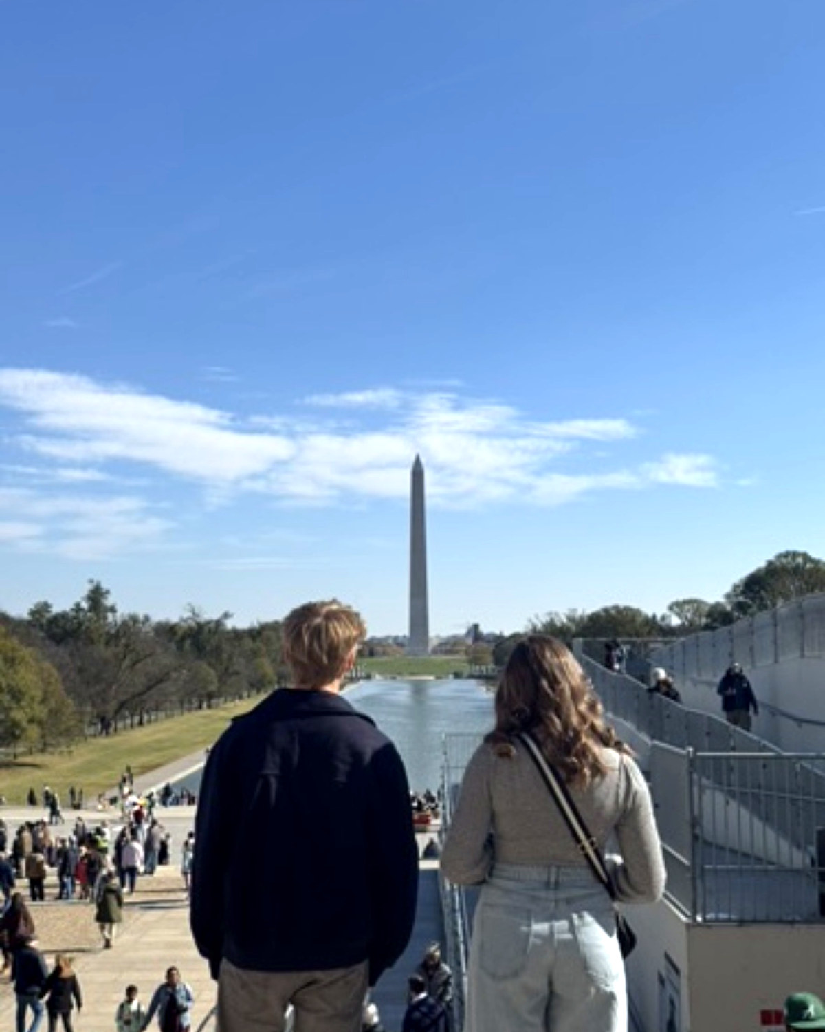 Two of the kids on the steps of the Lincoln Memorial looking down the reflecting pool at the Washington Monument