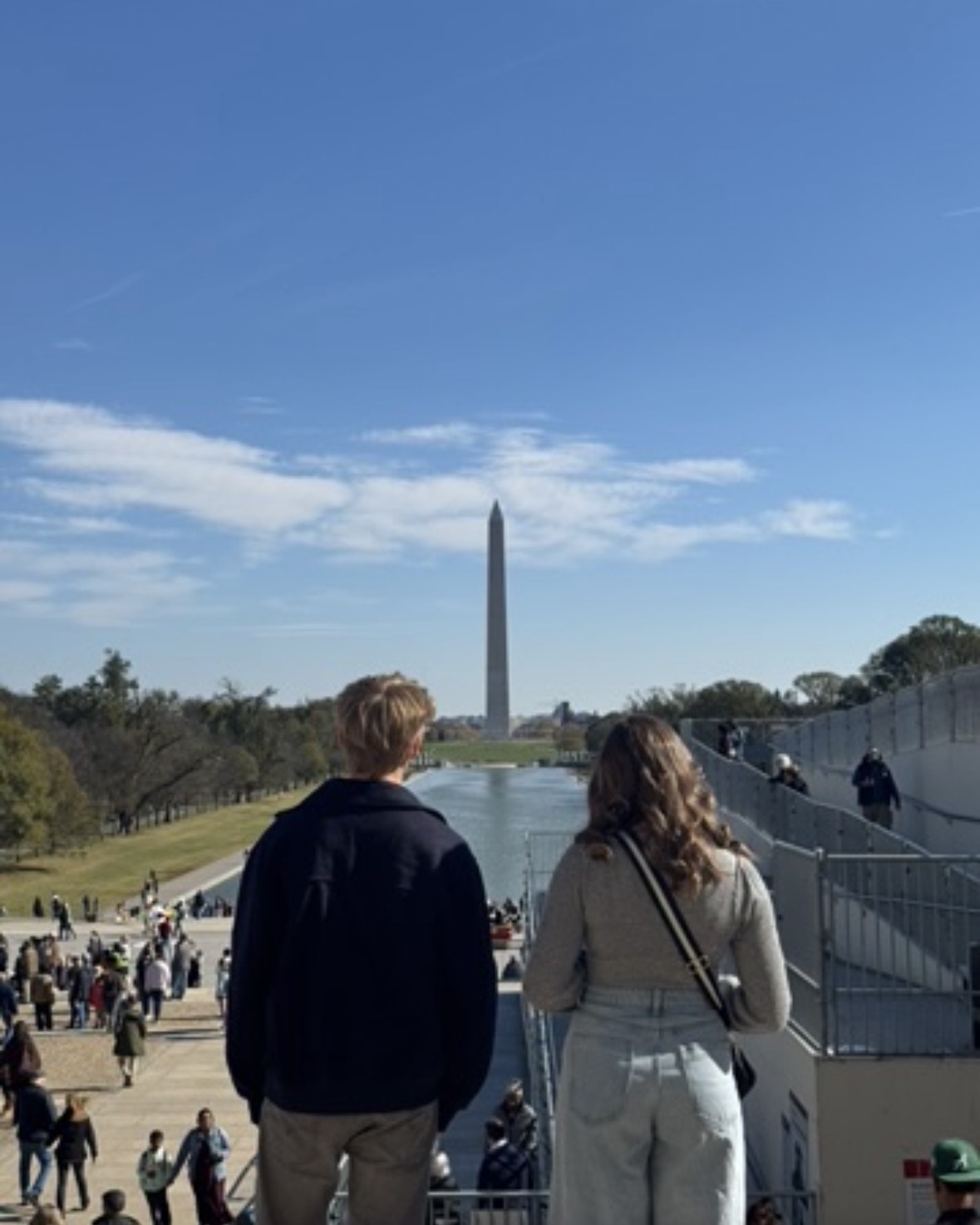 Two of the kids from behind on the steps of the Lincoln Memorial, looking down the mall at the Washington Monument