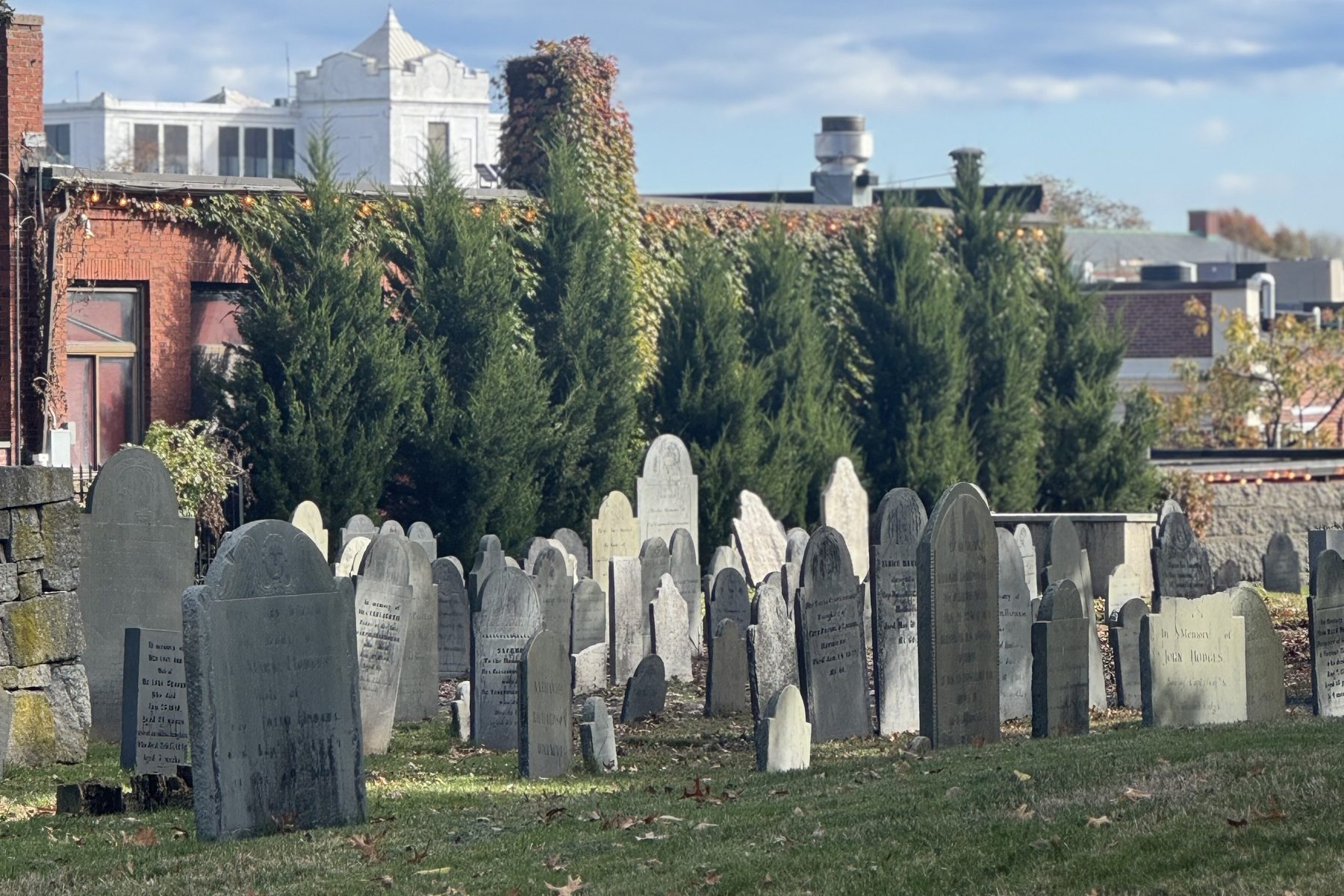 Old headstones in the Salem, Massachusetts burying ground on a blue sky fall day