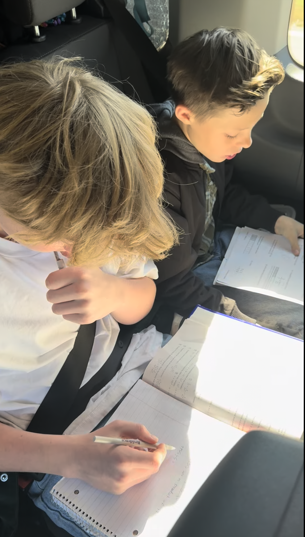 Two of the boys doing schoolwork in the van