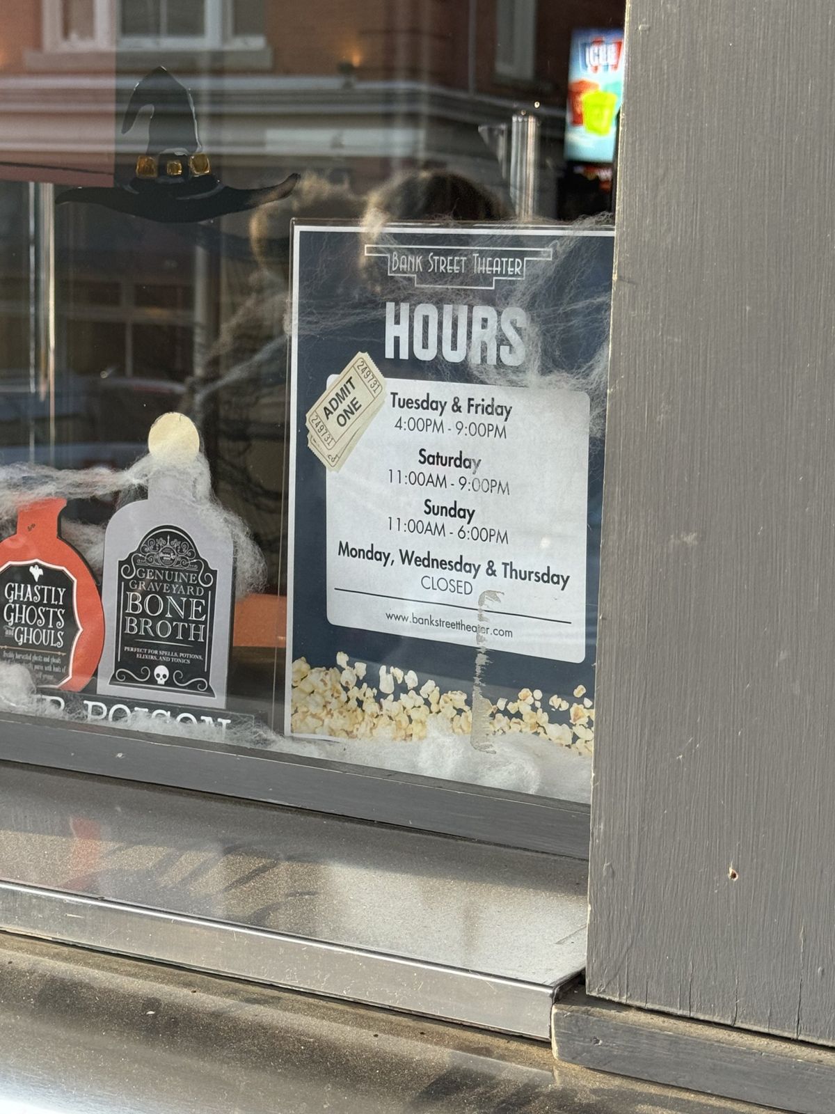 The hours sign in the Bank Street Theater window