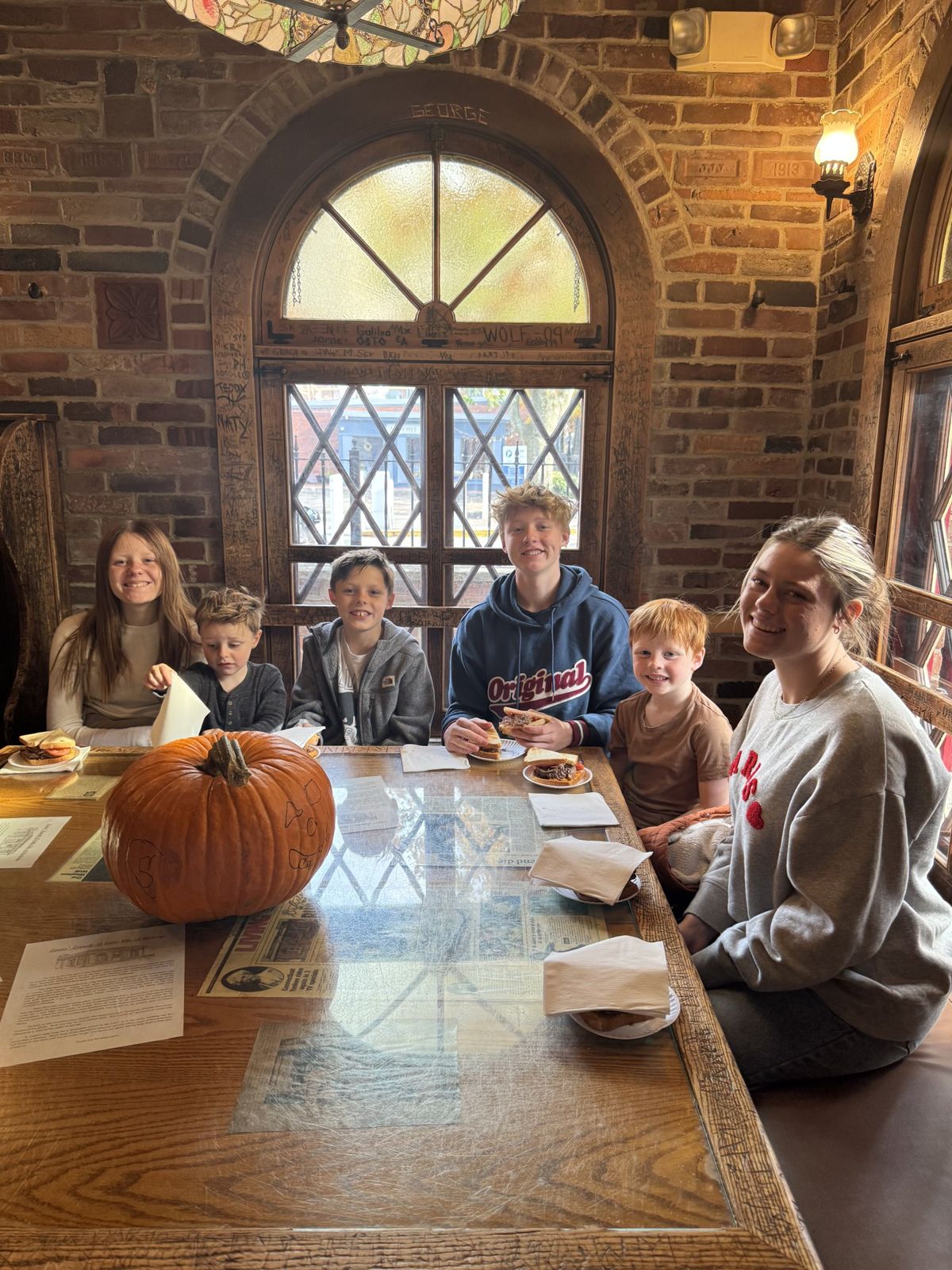 All of us at a wooden table inside Louis' Lunch