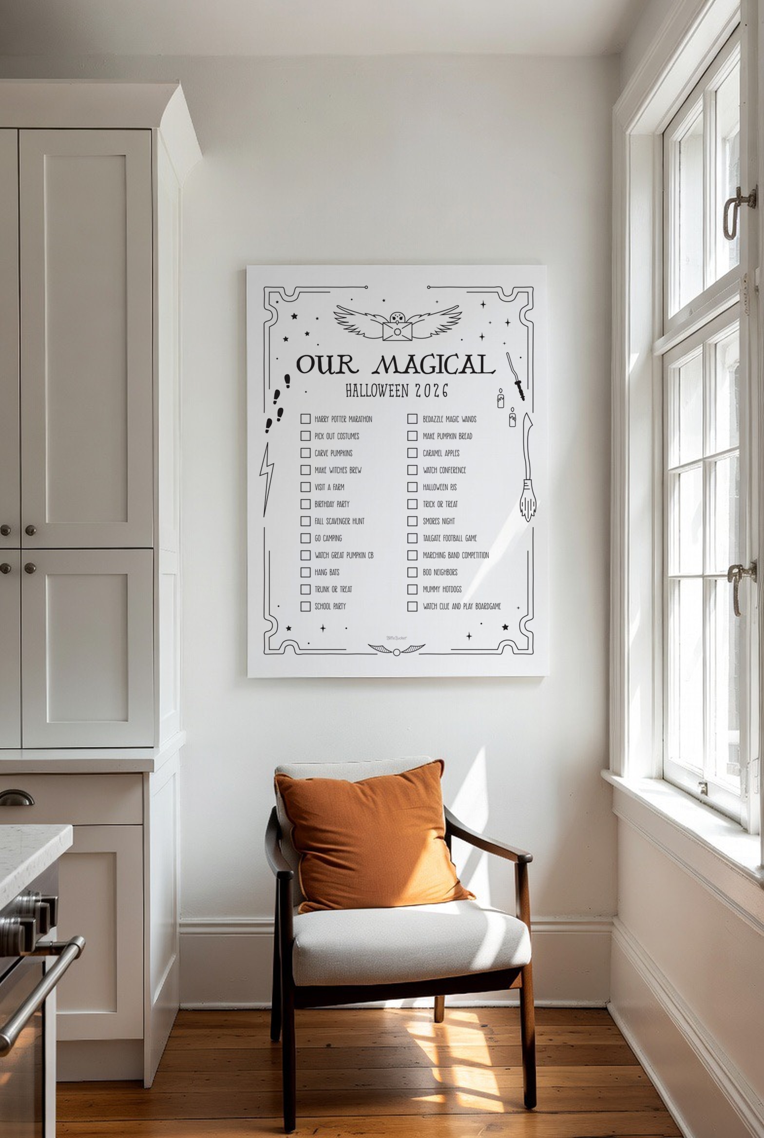 The Magical Halloween print on a white wall above a chair with an orange pillow