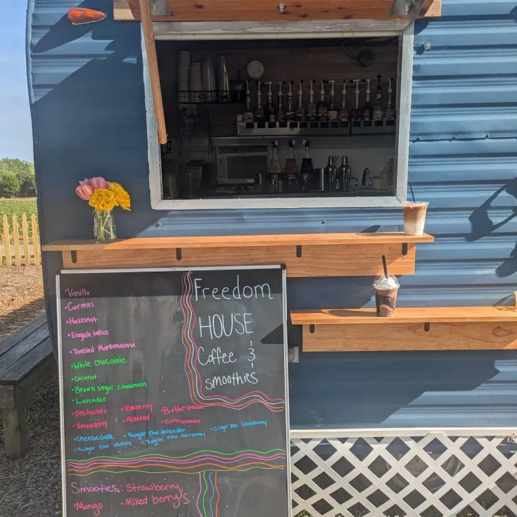 Exterior view of Freedom House coffee and smoothie cart with menu.