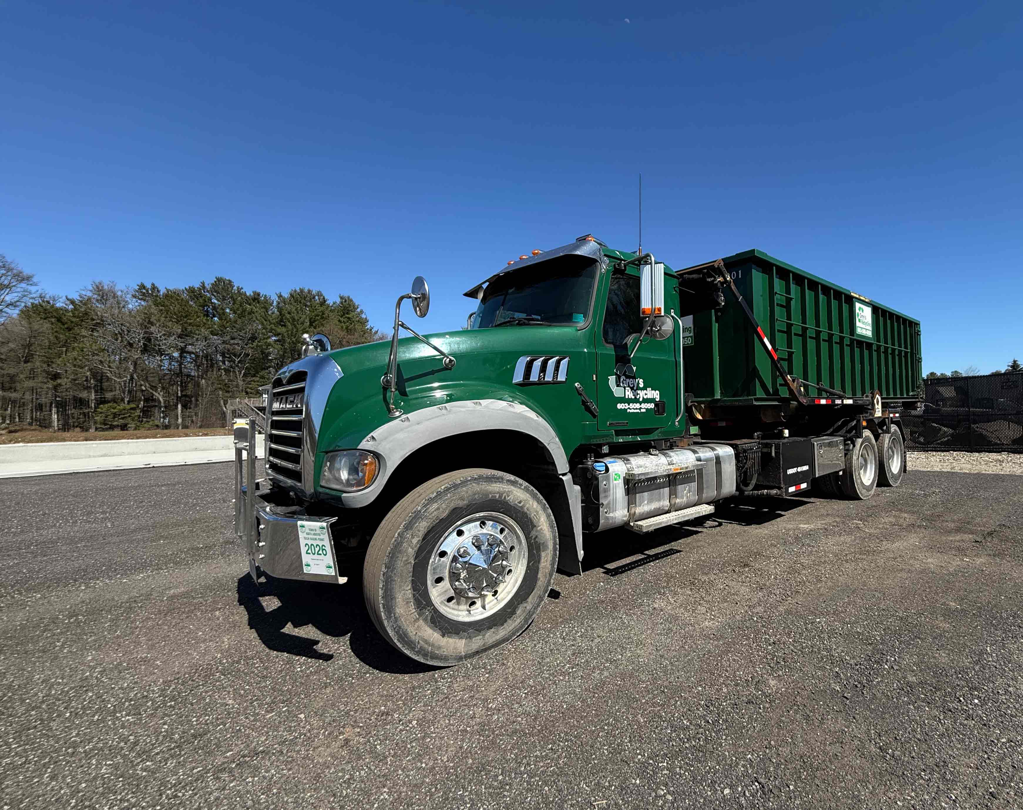 Grey’s Recycling truck delivering a 30-yard roll-off dumpster