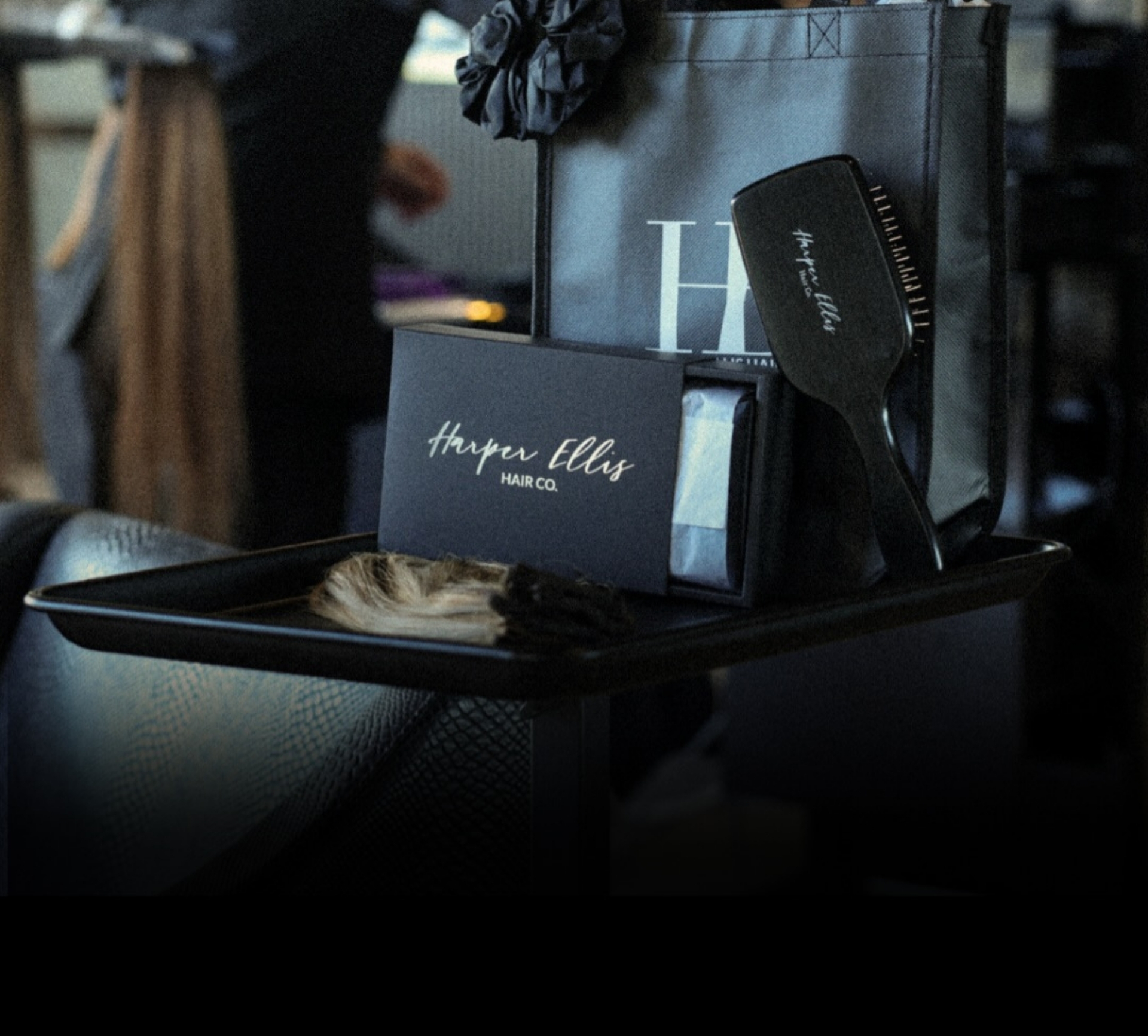 Hair care products including a Harper Ellis Hair Co. branded brush, box, and bag on a tray.