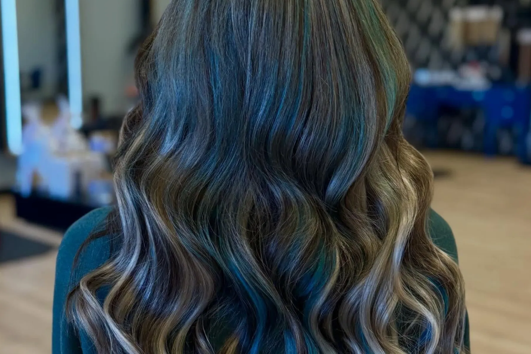Long wavy hair with blue and brown balayage highlights viewed from behind.