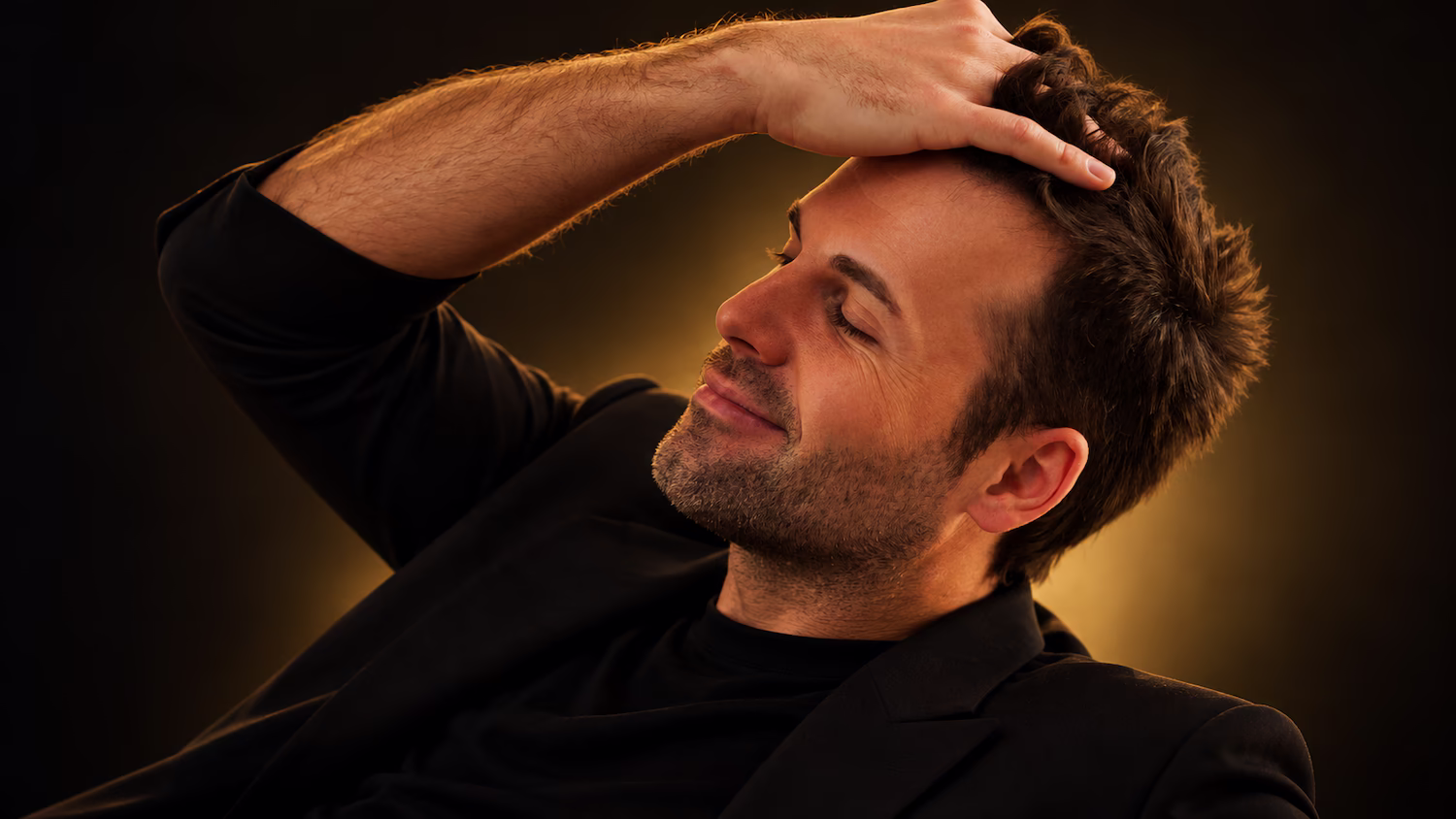 Man running a hand through his hair after hair restoration