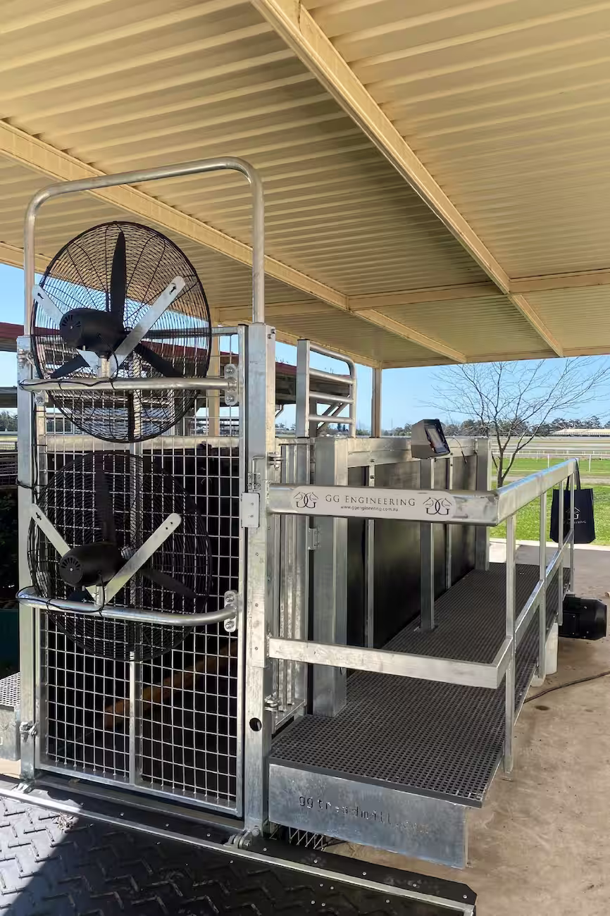 Equine therapy equipment installed at a training yard, including a treadmill and cooling fans