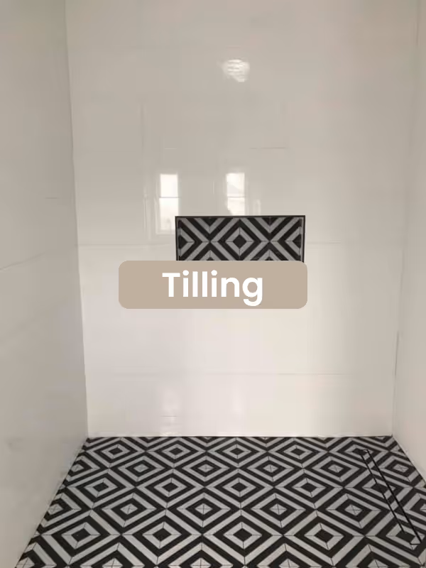 Tilling shower with white tiled walls and black and white geometric patterned tiles on the floor and niche.