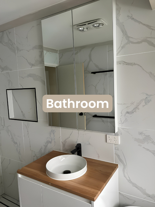 Modern bathroom vanity with white round vessel sink, wooden countertop, black faucet, and mirrored cabinet above.