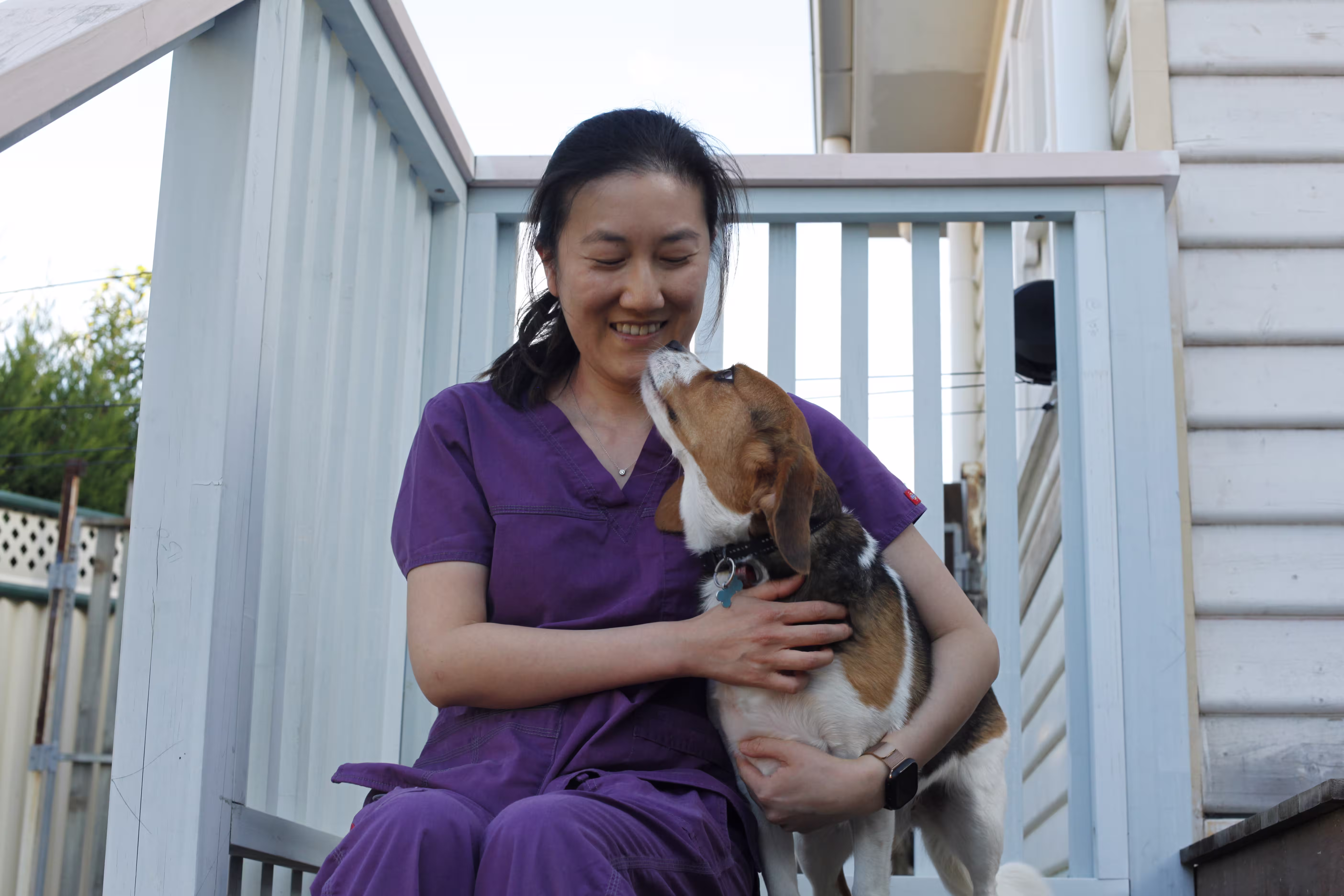 Dr winnie hugging a cute dog from a home vet visit
