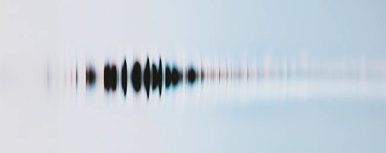 Abstract blurred black soundwave pattern on a light blue and white gradient background.