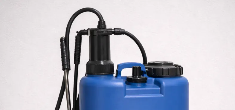 Blue backpack sprayer with black pump handle and attached hose.