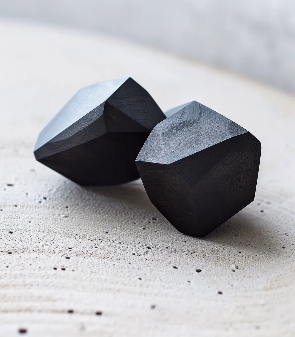 Zwei schwarze Steine auf beigem Hintergrund als Symbol für stabilen Funnel-Aufbau.
