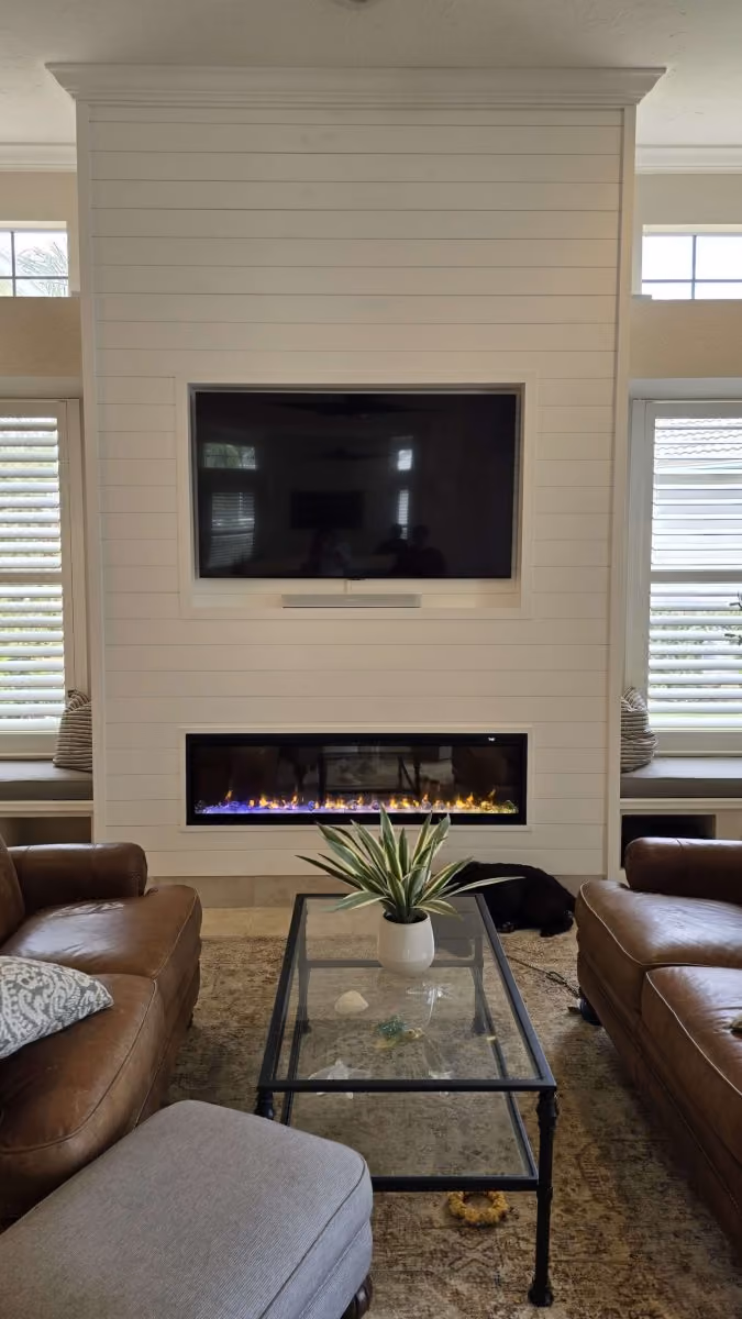 Living room with a shiplap fireplace wall and mounted television