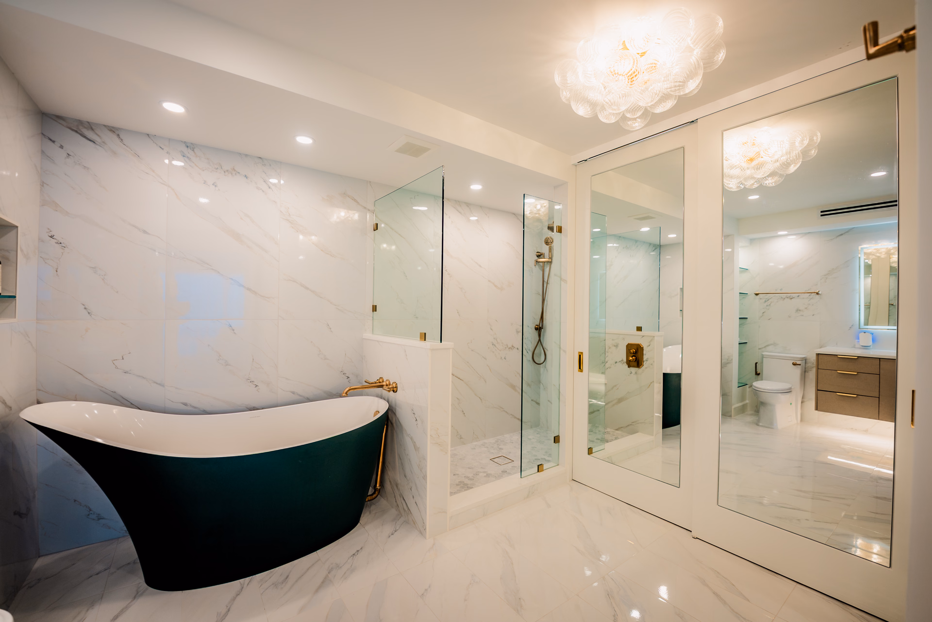 Custom master bathroom remodel by Grayhawk with a freestanding tub, walk in shower and mirrored doors