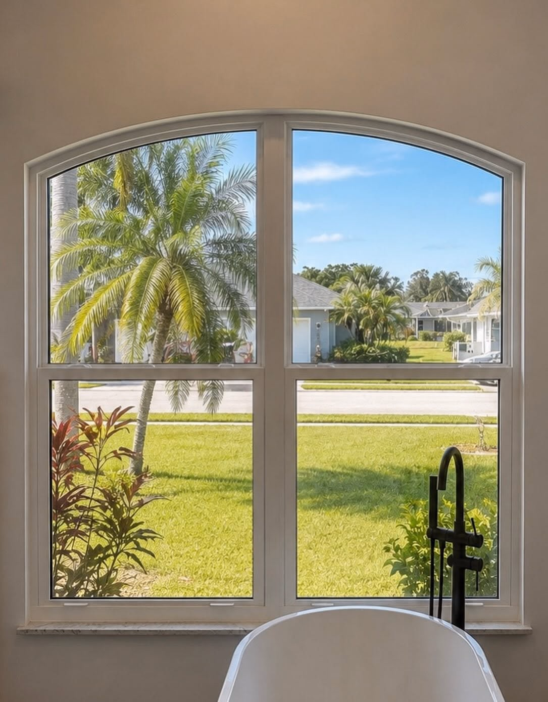 Arched window installed above a soaking tub