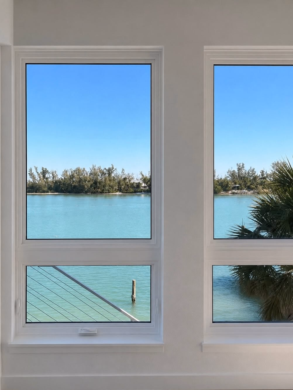 Impact windows framing a turquoise bay view in a Gulf Coast home
